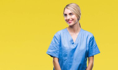Genç güzel sarışın doktor cerrah hemşire kadın yüzünden arka plan uzak tarafına gülümseme ile yüzünde, doğal ifade arıyorum izole. Kendine güvenen gülüyor.