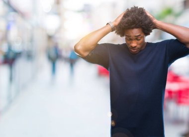 Afro Amerikalı adam çünkü umutsuz ve stresli baş ağrısı acı izole arka plan üzerinde ağrı ve migren. Ellerini kafasına.
