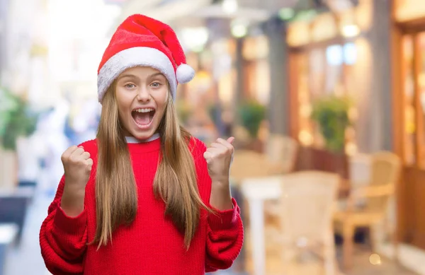 年轻美丽的女孩戴着圣诞节帽子在孤立的背景庆祝惊讶和惊讶的成功与双臂举起和睁开眼睛 获奖者概念 — 图库照片