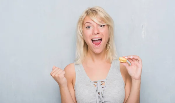 Ενηλίκων Καυκάσιος Γυναίκα Πάνω Από Grunge Γκρίζο Τοίχο Τρώει Macaron — Φωτογραφία Αρχείου