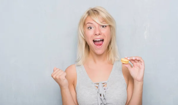 Mujer Caucásica Adulta Sobre Pared Gris Grunge Comiendo Macaron Gritando — Foto de Stock