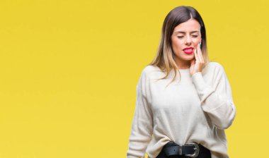 Genç güzel kadın diş ağrısı veya dişlerde dişlerle ilgili hastalık nedeniyle ağız acı ifadesi ile el ile dokunmak izole arka plan üzerinde rahat beyaz kazak. Diş hekimi kavramı.