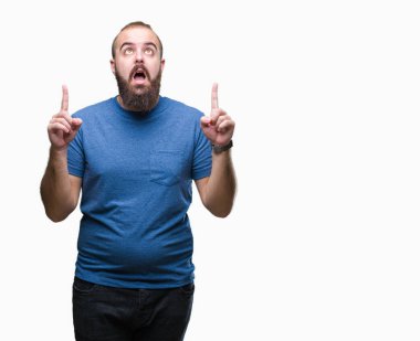 Genç beyaz hipster adam izole arka plan üzerinden hayran ve yukarıya bakıp parmakları ile işaret şaşırttı ve silah kaldırdı.