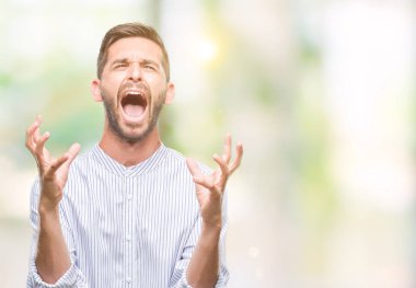 Genç yakışıklı adam izole arka plan çılgın ve kızgın bağırarak ve agresif ifade ve silah kaldırdı bağırıyor. Hayal kırıklığı kavramı.