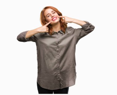 Genç güzel kadın kendinden emin gösterilen ve işaret parmakları diş ve ağız ile gülümseyen izole arka plan yüzünden. Sağlık kavramı.