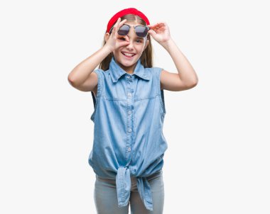 Genç güzel kız gülümsüyor, parmakları ile mutlu yüz üzerinden seyir göz el ile ok jest yapıyor izole arka plan üzerinde güneş gözlüğü takıyor.