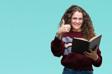 Genç esmer kız ok işareti, başparmak ile parmak, mükemmel işareti yapıyor kocaman bir gülümseme ile izole arka plan üzerinde mutlu gözlük takan bir kitap okuma