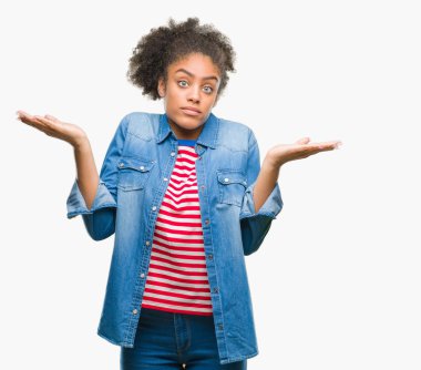 Genç afro Amerikan kadın izole arka plan clueless ve şaşkın bir ifadeyle kollar ve eller kaldırdı. Şüphe kavramı.