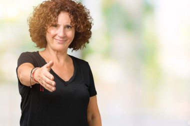 Güzel orta ager üst düzey kadın dostu sunan el sıkışma tebrik ve davet edici olarak gülümseyen izole arka plan yüzünden. Başarılı iş.