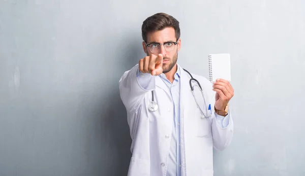 Bonito Jovem Médico Homem Sobre Parede Grunge Cinza Segurando Notebook — Fotografia de Stock