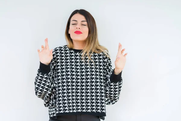 Young woman wearing casual sweater over isolated background smiling crossing fingers with hope and eyes closed. Luck and superstitious concept.