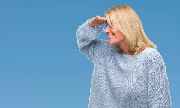 上冬のセーターを着て中年金髪女性は分離非常に幸せと笑顔の頭上の手で遠く離れている背景です 概念を検索 — ストック写真