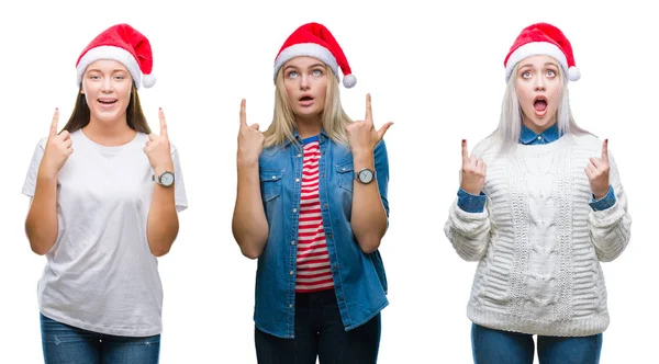 一群年轻妇女在孤立的背景下戴着圣诞帽 惊讶和惊讶地抬起头来 用手指指指点点 举起双臂 — 图库照片