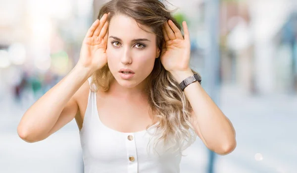 Hermosa Mujer Rubia Joven Sobre Fondo Aislado Tratando Escuchar Ambas — Foto de Stock