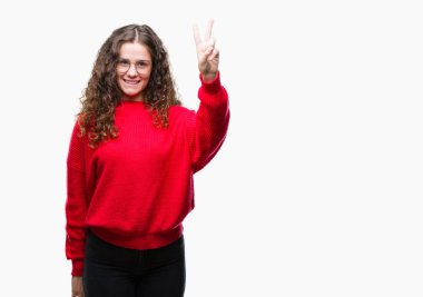 Gösterilen ve parmakları ile işaret izole arka plan üzerinde gözlük ve kış kazak giyen güzel esmer kıvırcık saçlı Genç kız kendinden emin ve mutlu gülümseyerek ise ikinci.