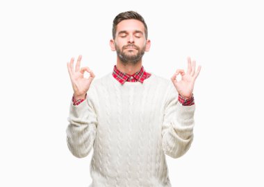 Genç yakışıklı adam giyen kış kazak izole arka plan üzerinde dinlenmek ve gülümseyen gözlerle parmak ile meditasyon jest yapıyor kapalı. Yoga kavramı.