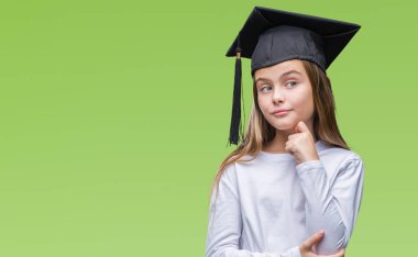 Genç güzel kız çene düşünme hakkında soru, dalgın ifade üzerine el ile izole arka plan üzerinde yüksek lisans şapkası. Düşünceli yüzüyle gülümsüyor. Şüphe kavramı.