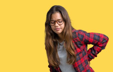 Genç güzel esmer kadın giyiyor ceket ve gözlük izole üzerinde el ile geri, kas ağrısı dokunmadan acı sırt ağrısı, arka plan