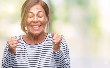 İspanyol kadın kıdemli orta yaş izole arka kolları olan başarı için heyecan üzerinde zafer kutluyor gülümseyen kaldırdı. Kazanan kavramı.