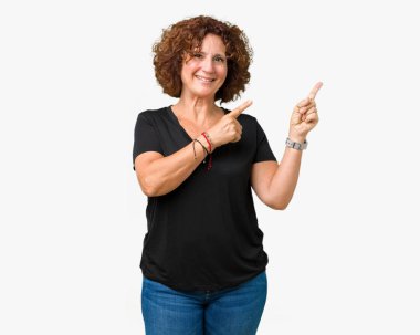 Gülümseyen ve iki elleri ve parmakları ile tarafına işaret kamera bakarak izole arka plan güzel orta ager üst düzey kadın.