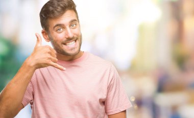 Yakışıklı delikanlı yapıyor gülümseyen izole arka plan üzerinde telefon hareketi ile el ve parmak telefonda konuşuyor gibi. Kavramları iletişim.