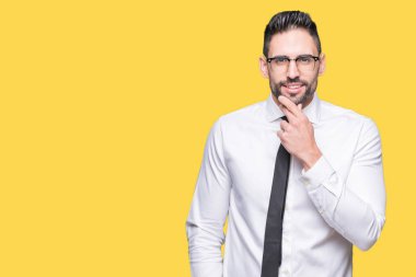 Emin çapraz kollar ve çeneme kaldırdı el ile gülümseme ile kameraya bakarak izole arka plan üzerinde gözlük takan genç yakışıklı iş adamı. Pozitif düşünce.