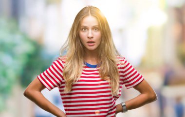 Genç güzel sarışın kadın izole arka plan korkuyor ve sürpriz ifade ile şok yüzünden korku ve yüz heyecanlı.