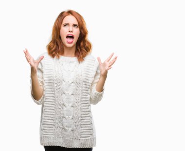 İzole arka plan kış kazak çılgın ve kızgın bağırarak ve agresif ifade ve silah kaldırdı bağırmaya giyen genç güzel kadın. Hayal kırıklığı kavramı.