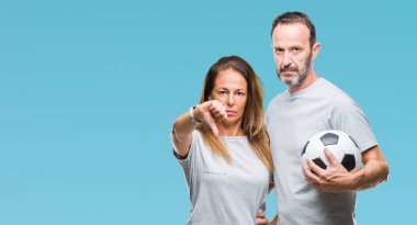 Orta yaş İspanyol çift futbol futbol topu tutan arka plan kızgın yüzü, eksi işareti aşağı antipati başparmak ile gösterilen, ret kavramı ile izole