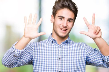 Genç yakışıklı iş adamı gösterilen ve parmakları ile işaret izole arka plan üzerinde kendinden emin ve mutlu gülümseyerek süre sekiz numara.