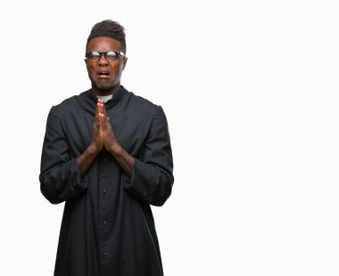 Yalvarıyor ve umut ifade yüzünde çok duygusal ve endişe ile birlikte elleriyle dua izole arka plan genç Afro-Amerikan rahip adam. Bağışlanmak. Din kavramı.