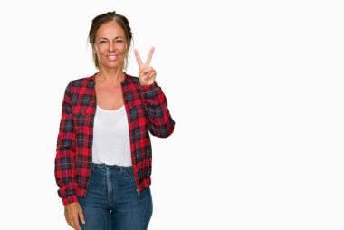 Gösterilen ve parmakları ile işaret izole arka plan üzerinde rahat ceket giyen orta yaş yetişkin kadın ikincisi ise kendinden emin ve mutlu gülümseyerek.