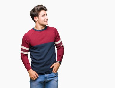 Yakışıklı delikanlı uzak tarafına yüzünde, doğal ifade gülümseme ile seyir izole arka plan üzerinde. Kendine güvenen gülüyor.