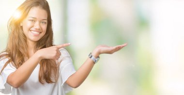 Genç güzel esmer iş kadını üzerinden hayran ve el ile sunulması ve parmak ile işaret ederken kameraya gülümseyen izole arka plan.