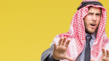 Uzun saçlı keffiyeh üzerinde giyen genç yakışıklı Arap adam arka plan korkuyor ve korku ifade dur hareketi el ile ile dehşete şokta bağırarak izole. Panik kavramı.