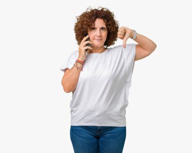 Orta ager üst düzey kadın Smartphone'da kızgın yüzü, eksi işareti aşağı antipati başparmak ile gösterilen, ret kavramı ile izole arka plan üzerinde söz