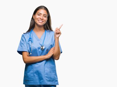 Kameraya bakarak yan el ve parmak ile işaret eden genç Arap Doktor cerrah kadının yüzünde kocaman bir gülümseme ile izole arka plan üzerinde.