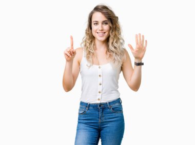 Genç güzel sarışın kadın gösterilen ve parmakları ile işaret izole arka plan yüzünden kendinden emin ve mutlu gülümseyerek süre 6 numara.