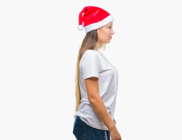 年轻美丽的白人妇女戴着圣诞节帽子在孤立的背景寻找侧 放松的轮廓姿势与自然脸与自信的微笑 — 图库照片