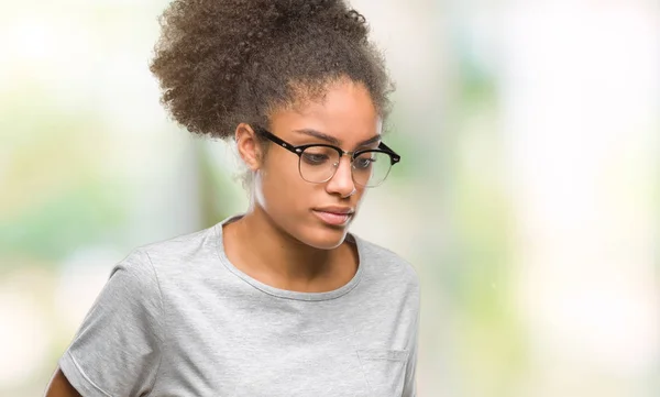 Young afro american woman wearing glasses over isolated background with hand on stomach because nausea, painful disease feeling unwell. Ache concept.