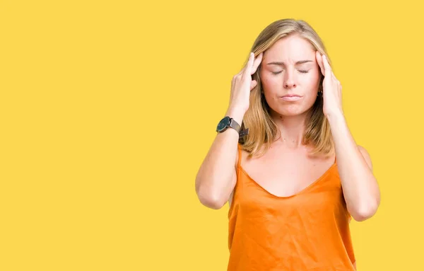 上オレンジ色のシャツを着ての美しい若い女性は頭の頭の中の痛みのために手でバック グラウンドを分離したストレス 片頭痛に苦しんでいます — ストック写真