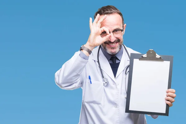 中年老年白发医生男子拿着剪贴板孤立的背景与快乐的脸微笑做确定的标志与眼睛看着通过手指 — 图库照片
