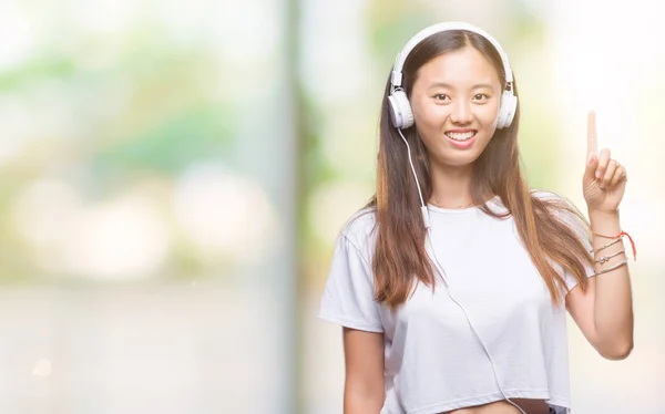 Junge Asiatische Frau Hört Musik Mit Kopfhörern Isoliert Hintergrund Überrascht — Stockfoto