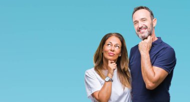 Orta yaş İspanyol rahat çift ile izole arka plan üzerinde çene düşünme hakkında soru, dalgın ifade ver. Düşünceli yüzüyle gülümsüyor. Şüphe kavramı.