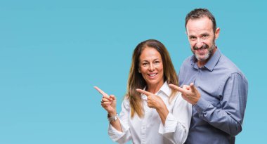 Orta yaş İspanyol iş çift gülümseyen ve iki elleri ve parmakları ile tarafına işaret kamera bakarak izole arka plan üzerinde.