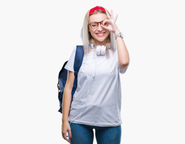 Genç sarışın öğrenci kadın gözlük ve sırt çantası el gülümseyen, ok jest yapıyor izole arka plan üzerinde göz parmakları ile mutlu yüz üzerinden seyir.