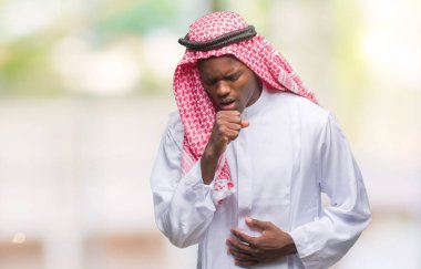 Geleneksel keffiyeh duygu hasta ve soğuk veya bronşit için semptom olarak öksürük izole arka plan üzerinde giyen genç Arapça Afrika adam. Sağlık kavramı.
