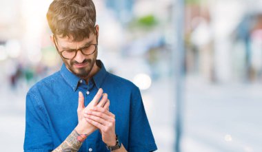 Elleri ve parmakları, artrit inflamasyon izole arka plan acı acı üzerinde gözlük takan genç yakışıklı adam