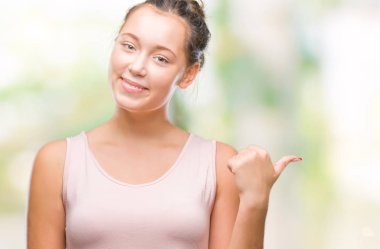 Seyir ve başparmak yanında yukarıyı mutlu yüz ile gülümseyen izole arka plan üzerinde beyaz genç güzel kadın.