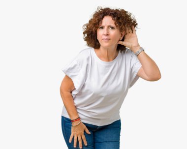 Bir işitme söylenti ya da dedikodu için dinleme kulak üzerinde el ile gülümseyen izole arka plan üzerinde beyaz t-shirt giyen güzel orta ager kadın kıdemli. Sağırlık kavramı.